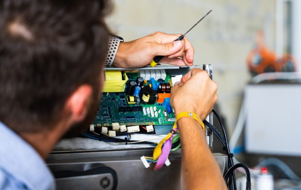 Technicien en intervention sur la carte électronique d'une unité de froid
