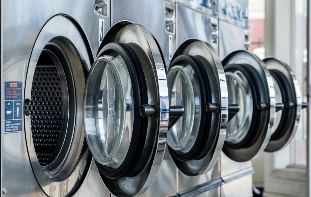 Hublots de lave-linge professionnels en inox dans une laverie